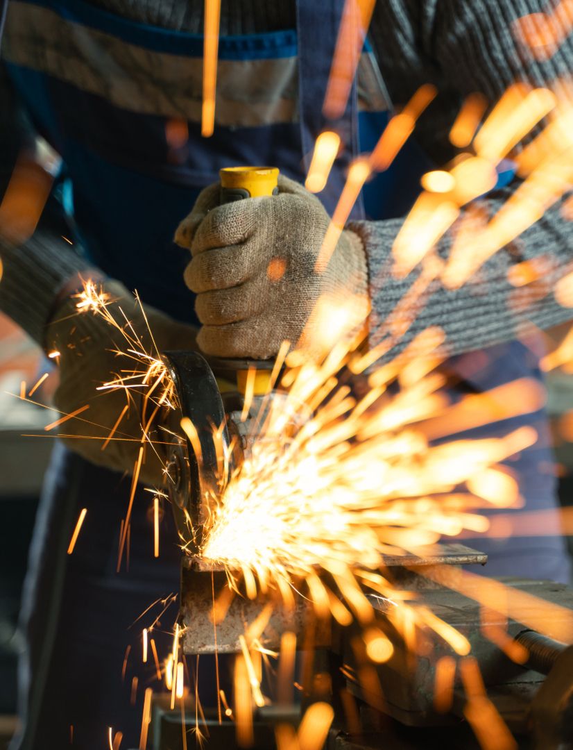 Mann im blauen Overall beim Schweißen